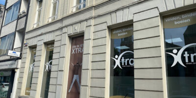 De buitenkant van het Xtra interim & selectie kantoor in Turnhout met stickers en logo's van Xtra